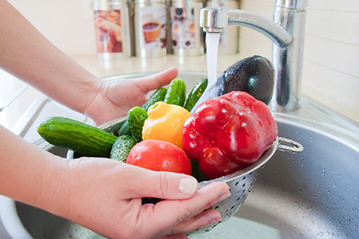 Washing vegetables under a tap