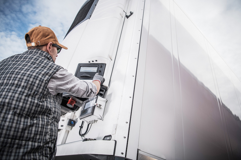 Man checking the control panel on a transport lorry 